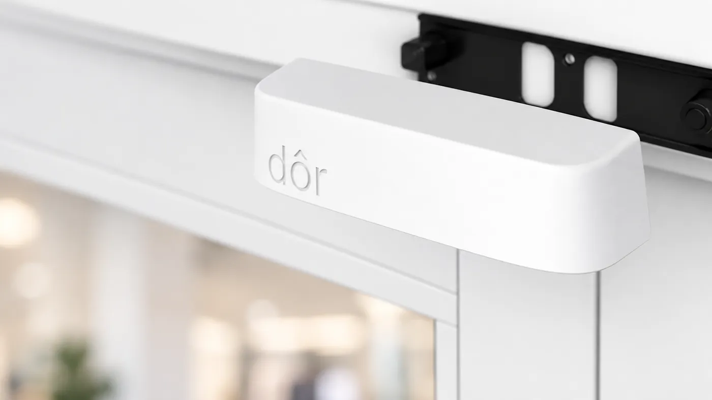 A white Dor sensor mounted above a store entrance.